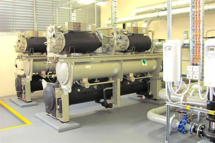 Water-cooled chiller in a plant room with pipework and control cabinets.